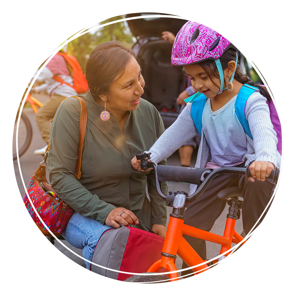 Mother teaching daughter to ride a bike